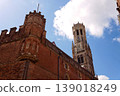 Sunny view of the Belfry of Bruges rising above the historic Markt square, showcasing medieval Flemish architecture under a clear blue sky, Brugge, West Flanders, Belgium 139018249