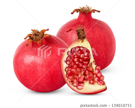 Two pomegranate fruits and a cut with seeds isolated. 139018731
