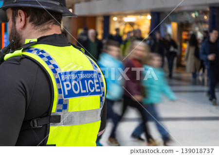 Police officer watching over a crowded public transport hub 139018737