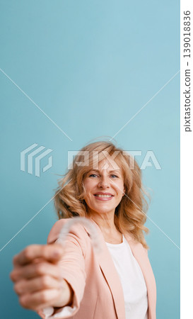Mature woman smiling holding invisible braces on blue background Mature woman smiling holding invisible braces on blue background 139018836