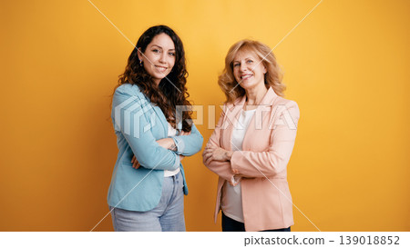Two smiling businesswomen standing together with arms crossed 139018852