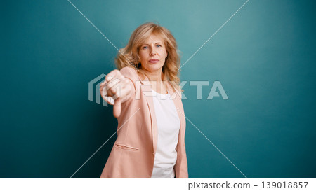 Woman showing thumbs down gesture expressing disliking Woman showing thumbs down gesture expressing disliking 139018857