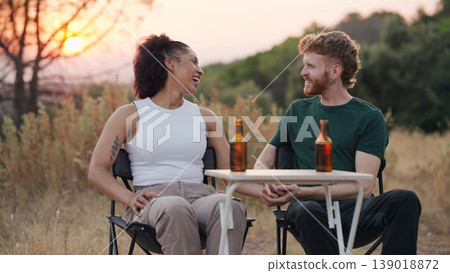 Couple traveling and laughing outdoors at sunset Couple traveling and laughing outdoors at sunset 139018872