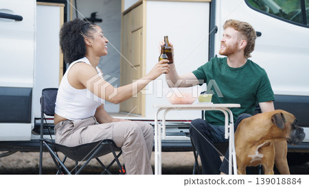 Couple toasting during camper van picnic with dog Couple toasting during camper van picnic with dog 139018884