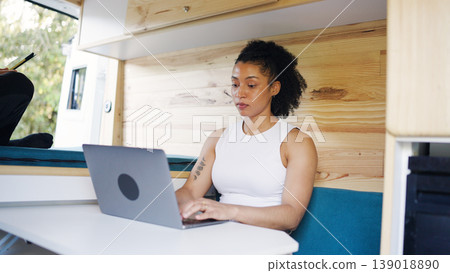 Woman working on laptop inside camper van Woman working on laptop inside camper van 139018890