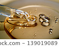 Pipette drawing golden liquid serum with bubbles 139019089