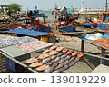 Fish are sun-dried on nets outdoors, with fishing boats anchored far away, at Ban Amphoe beach ,Thailand. 139019229