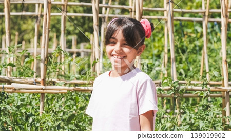 Happy girl looking at camera while standing at community garden Happy girl looking at camera while standing at community garden 139019902