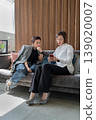 Businesswomen holding notepad brainstorming and discussing together sitting on sofa at office. Brainstorm, notepad, business, teamwork, office. 139020007