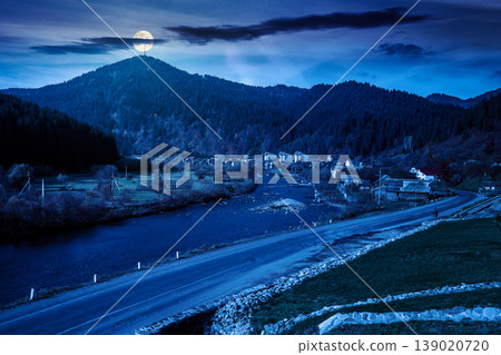 mountain landscape during fall season at night. full moon over rural scenery with river. picture of a countryside road through valley near village for travel background. mysterious fantasy mountain landscape during fall season at night. full moon over rural scenery with river. picture of a countryside road through valley near village for travel background. mysterious fantasy 139020720