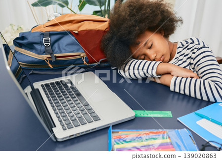 Little schoolgirl fell asleep during online learning at home, put her curly head on the school table after a hard lesson, and rests Little schoolgirl fell asleep during online learning at home, put her curly head on the school table after a hard lesson, and rests 139020863