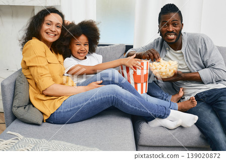 Happy African American family enjoying watching a movie in their home on TV Happy African American family enjoying watching a movie in their home on TV 139020872
