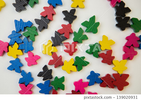 Small multi-colored figures of people lie in a chaotic order on a white background. The concept of people, society. High quality photo Small multi-colored figures of people lie in a chaotic order on a white background. The concept of people, society. High quality photo 139020931