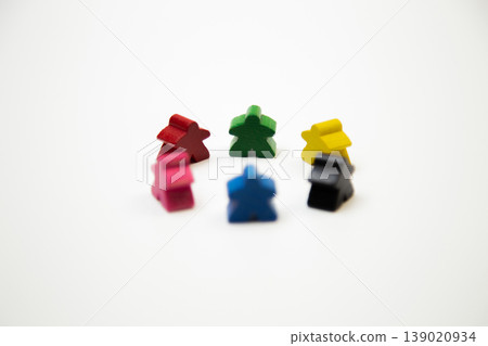 Small multi-colored wooden men of different colors stand in a circle on a white background in the center. The concept of people, society, meetings, meetings. High quality photo Small multi-colored wooden men of different colors stand in a circle on a white background in the center. The concept of people, society, meetings, meetings. High quality photo 139020934