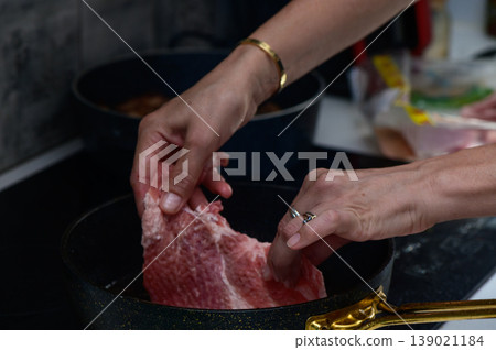 Cooking a delicious meal with seasoned hands in a cozy kitchen environment Cooking a delicious meal with seasoned hands in a cozy kitchen environment 139021184