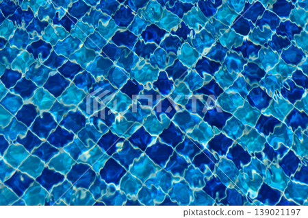Rippling reflections dance on the shimmering surface of clear blue swimming pool 139021197