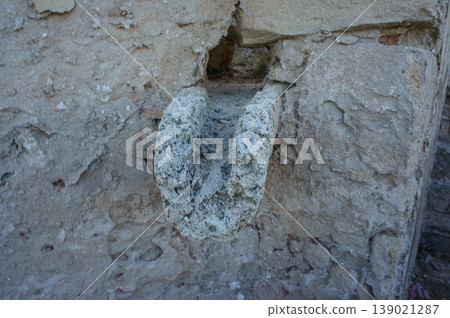 Ancient stone carving in a weathered wall, depicting artistic craftsmanship from a bygone era. Ancient stone carving in a weathered wall, depicting artistic craftsmanship from a bygone era. 139021287