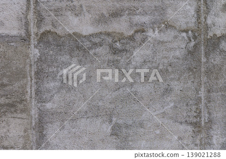 A textured concrete wall with subtle shading, revealing signs of wear and age in an urban setting 139021288