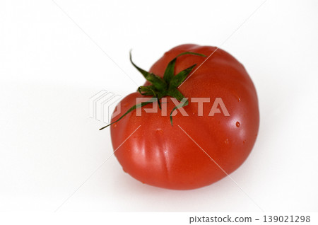 Freshly harvested organic heirloom tomato resting on a bright white background Freshly harvested organic heirloom tomato resting on a bright white background 139021298