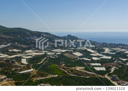 A breathtaking view of green fields and coastal landscape in a vibrant agricultural region under a clear blue sky A breathtaking view of green fields and coastal landscape in a vibrant agricultural region under a clear blue sky 139021328