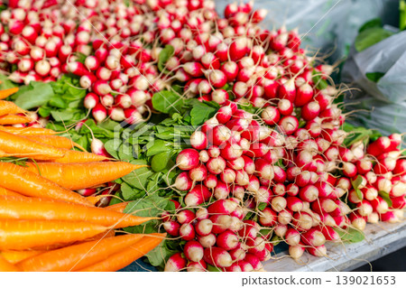 Fresh radishes and carrots for sale at a market stall Fresh radishes and carrots for sale at a market stall 139021653