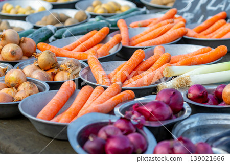 Carrots and onions for sale at a market stall Carrots and onions for sale at a market stall 139021666