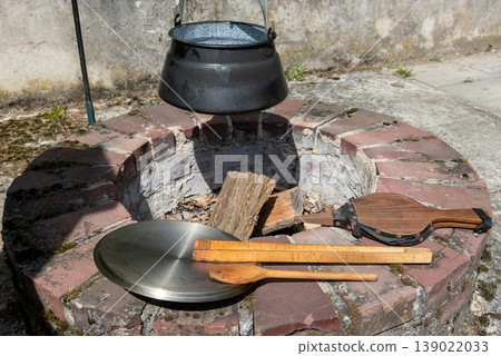 built-in fireplace in garden with cauldron and cooking utensils built-in fireplace in garden with cauldron and cooking utensils 139022033
