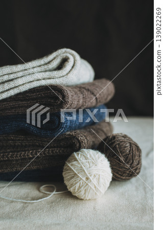 Hand knitted socks with yarn balls on a dark background. Concept for handmade and hygge slow life. Hand knitted socks with yarn balls on a dark background. Concept for handmade and hygge slow life. 139022269