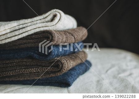 Hand knitted socks with on a dark background. Concept for handmade and hygge slow life. Hand knitted socks with on a dark background. Concept for handmade and hygge slow life. 139022288