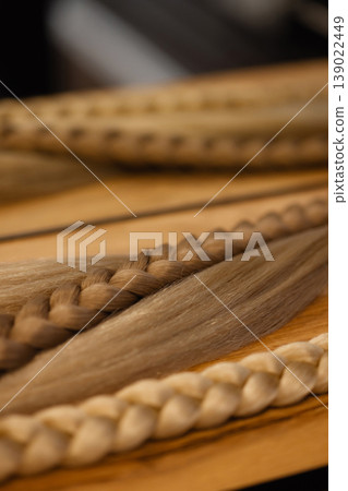 Blonde braid extensions on wooden table with metal rings 139022449