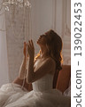 Refined Woman Dressed Stylishly Looks At Glowing Ceiling Lamp Amidst Soft Shadows 139022453