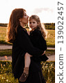 Sunset Walk With Family Members. Serene Family Scene During Sunset In Vast Grassy Landscape 139022457
