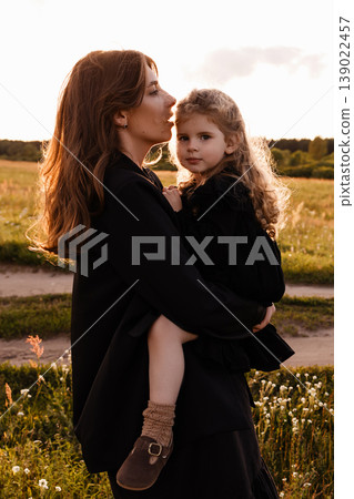 Sunset Walk With Family Members. Serene Family Scene During Sunset In Vast Grassy Landscape Sunset Walk With Family Members. Serene Family Scene During Sunset In Vast Grassy Landscape 139022457