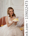 Bridal Cake Celebration. Joyful Bride Beams While Holding Cake With Twinkle Reflections 139022473