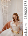 Joyful Wedding Display. Luminous Bride Showcasing Delicate Cake With Charming Accessories 139022478