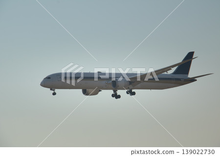 Large commercial airplane flying low during final approach phase, isolated against soft sky background with ample copy space for aviation, travel, and logistics concepts. Large commercial airplane flying low during final approach phase, isolated against soft sky background with ample copy space for aviation, travel, and logistics concepts. 139022730