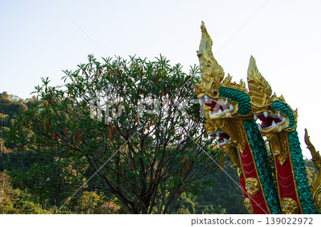 Naga serpent statue at a public Buddhist temple, guardian sculpture with ornate details, symbol of protection, culture and spirituality. 139022972