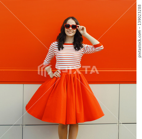 Beautiful happy young woman posing in red heart shaped sunglasses, skirt Beautiful happy young woman posing in red heart shaped sunglasses, skirt 139023288