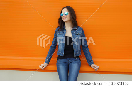 Happy young woman, modern girl looking away posing on bright background Happy young woman, modern girl looking away posing on bright background 139023302