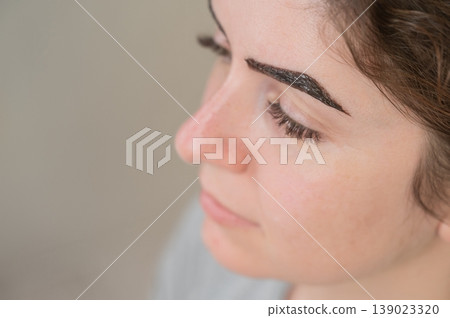 Caucasian woman getting eyebrow tinting procedure. Caucasian woman getting eyebrow tinting procedure. 139023320