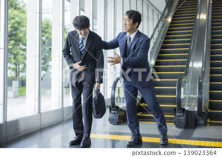 Businessman riding escalator Businessman riding escalator 139023364