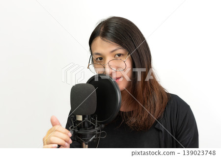 LGBTQ content creator recording voice with microphone in studio wearing glasses confident expression modern media production communication and creative lifestyle concept LGBTQ content creator recording voice with microphone in studio wearing glasses confident expression modern media production communication and creative lifestyle concept 139023748
