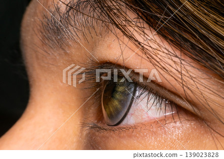 Extreme close up human eye wearing colored contact lens detailed iris texture eyelashes and skin showing vision care beauty fashion and optical concept Extreme close up human eye wearing colored contact lens detailed iris texture eyelashes and skin showing vision care beauty fashion and optical concept 139023828