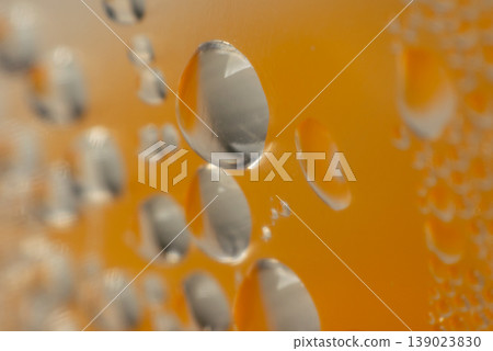 Macro water droplets on cold beer glass with warm golden tone background refreshing beverage detail condensation surface abstract texture closeup Macro water droplets on cold beer glass with warm golden tone background refreshing beverage detail condensation surface abstract texture closeup 139023830