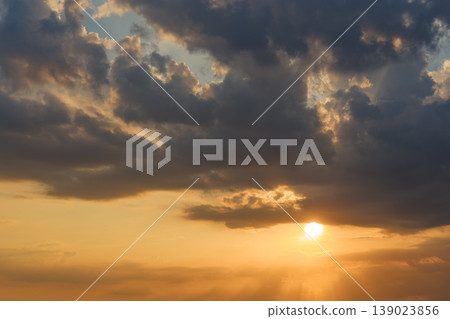 The sunset's gradation of light shines through the gaps in the clouds. The sunset's gradation of light shines through the gaps in the clouds. 139023856