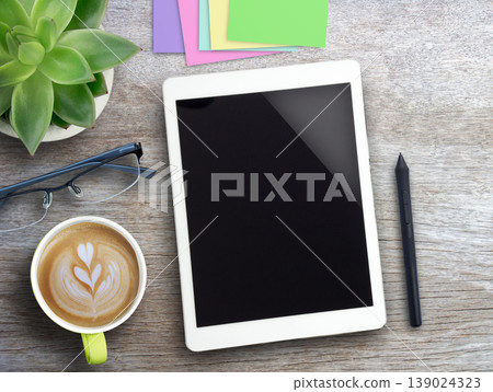 Tablet,pen mouse,sticky notes and coffee with flower on wood table background. 139024323