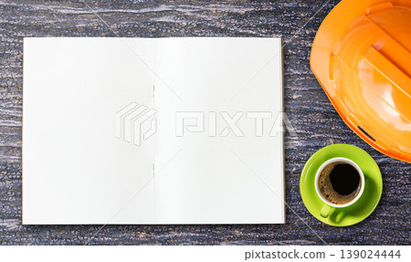 Top view orange safety helmet and coffee on wooden table background Top view orange safety helmet and coffee on wooden table background 139024444