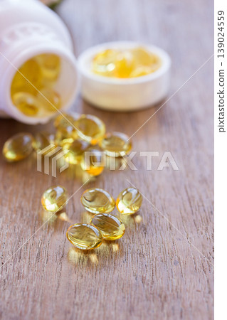 Omega 3 fish liver oil capsules in wooden background. 139024559