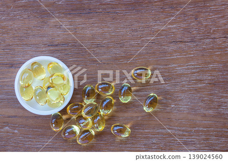 Omega 3 fish liver oil capsules on wooden background. Omega 3 fish liver oil capsules on wooden background. 139024560