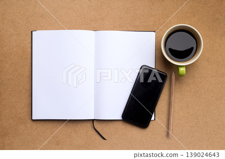 Top view with blank notebook,smartphone,pencil and coffee on brown wood table background. Top view with blank notebook,smartphone,pencil and coffee on brown wood table background. 139024643